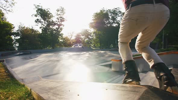 Aggressive Inline Roller Skater Doing Tricks in Concrete Skatepark Outdoors Slow Motion