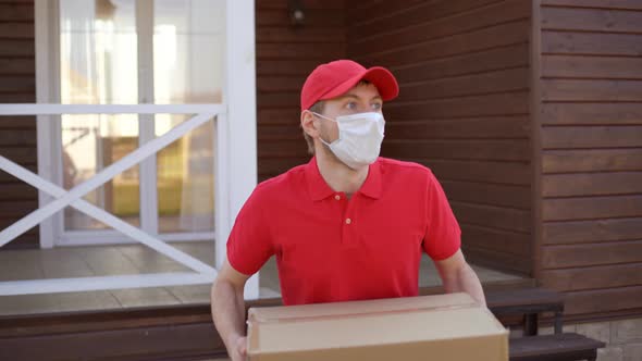 Delivery man in face mask holding box, running and hurrying to deliver goods