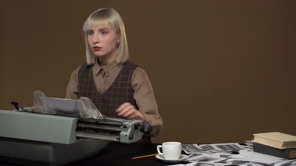 Portrait of Young Female Stenographer Typing Prohibited Information or Denunciation Using Typewriter