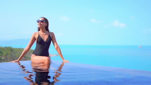 Young asian woman enjoy around outdoor swimming pool for leisure