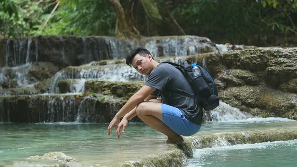 Man Sitting In Wild River and Looking at Camera