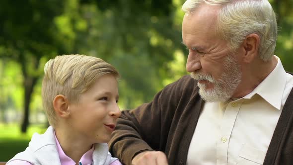 Grandson and Grandfather Laughing and Having Fun Enjoying Day in Park Together