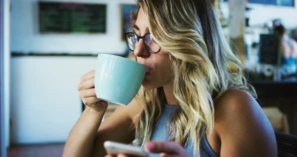 Woman Using Smartphone in Cafe