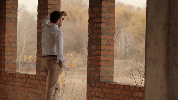 Man On Window And Looking At Distance. Businessman In White Shirt Standing In Unfinished House.