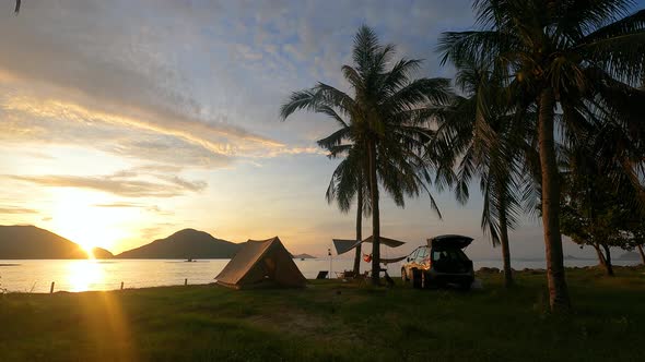 Time-lapse footage of sunrise on the beach with tent and camping car on the sea shore