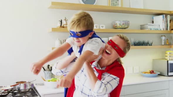 Mother and son pretending to be superhero in living room