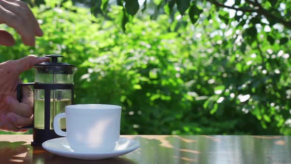 Herbal Drink Against the Backdrop of the Morning Summer Garden