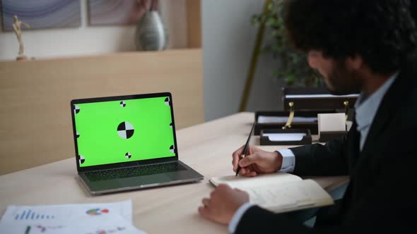 Over the Guy's Shoulder View of a Laptop with a Chromatic Green Screen