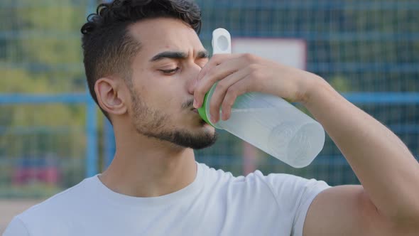 Closeup of Middle Eastern Indian Man Athlete Latino Runner Quenching Thirst After Jogging