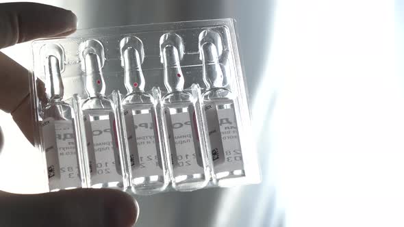 Hold the Glass Medical Ampoule with the Liquid