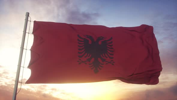 Flag of Albania Waving in the Wind Sky and Sun Background