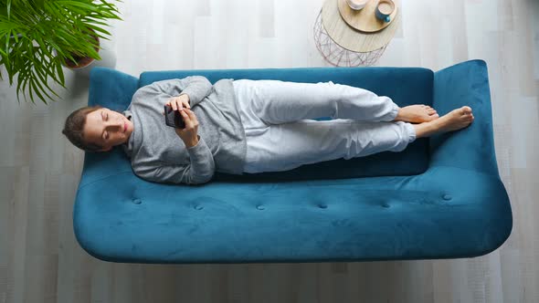 Overhead Shot of Happy Relaxed Woman Holding Smart Phone Using Mobile Apps Watching Funny Video