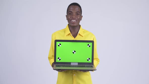 Young Happy African Businessman Showing Laptop and Looking Surprised