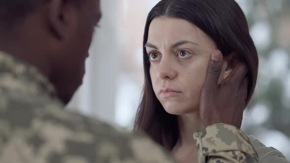 Headshot of Sad Young Gorgeous Caucasian Woman Looking at African American Man Touching Face of