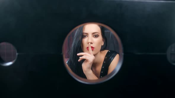 Closeup Sexual Bdsm Woman in Latex Making Silence Gesture Looking Through Block Handcuffs