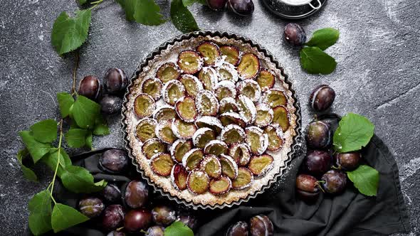 Homemade Delicious Plum Tart with with Sugar Powder Placed on the Table