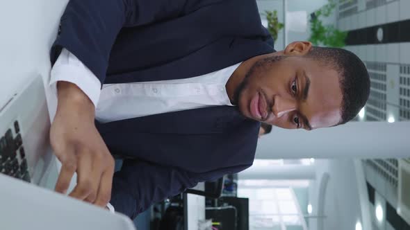 Vertical Screen Black Businessman Using Laptop in Coworking Space