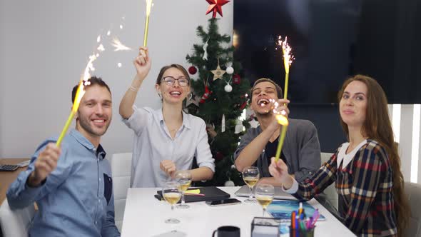 Excited Office Colleagues Celebrating Christmas Corporate Party Waving with Golden Sparkles