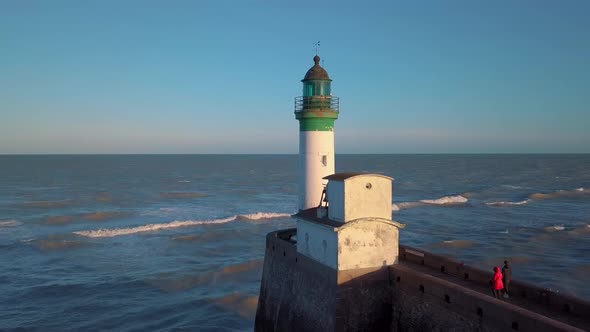 Aerial side view of the white lighthouse at sunset, 4k video