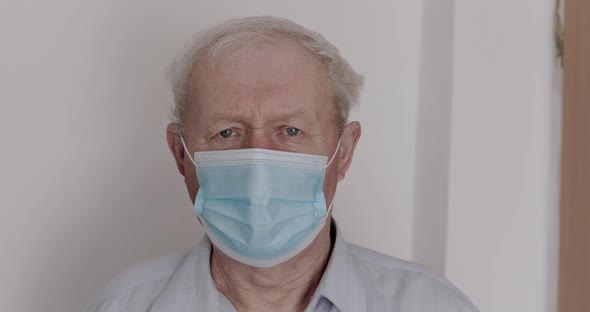 Serious Looking at Camera of Grandfather Wore in Medical Mask on Isolation