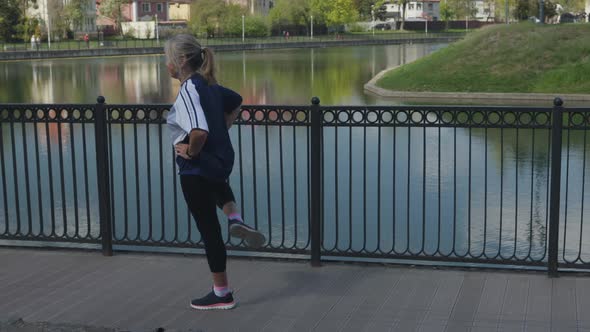 Old Senior Woman Doing Sports Outdoors Training Balance Trying to Stand One Leg