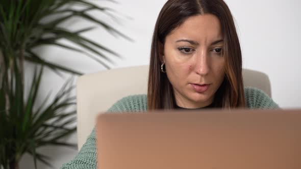 Close Up of Young Hispanic Woman Working on Laptop From Home