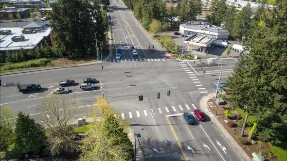 Aerial timelapse of a busy intersection, cars, trucks, and traffic moving as the lights change