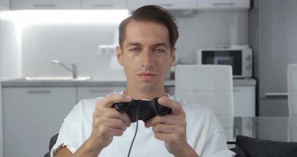 Man with Joystick Actively Playing Games on Couch Loosing Console Game
