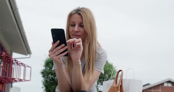 Young happy woman using smartphone at the park.