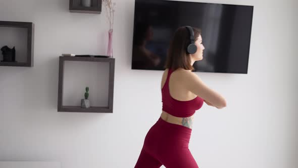 Woman Putting on Music in Headphones and Starting Stretching Legs