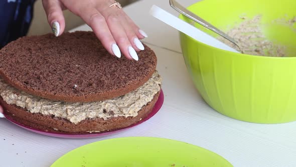 A Woman Is Folding Biscuit Cakes, Smeared With Cream.