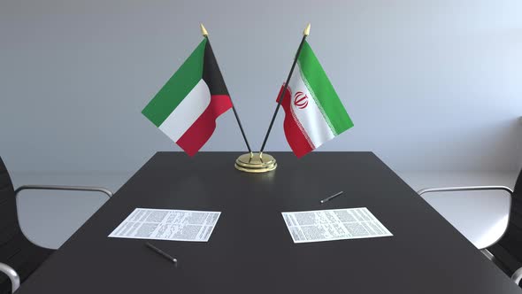 Flags of Kuwait and Iran and Papers