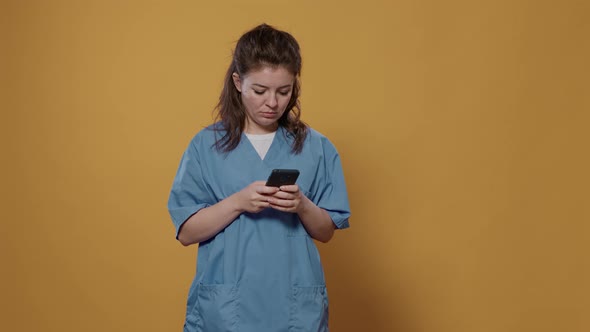 Portrait of Professional Medic Holding Smartphone and Texting and Showing Green Screen Mockup Design