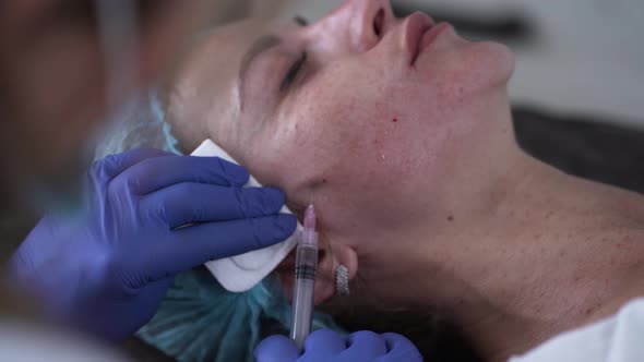 Woman on the Procedure of Mesotherapy Injection with a Syringe