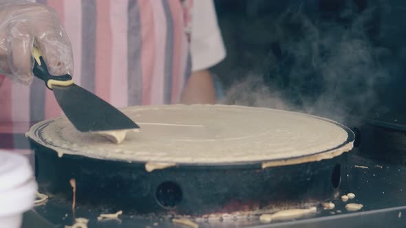 Woman Prepares Pancake on Crepe Maker in Fast Food Cafe