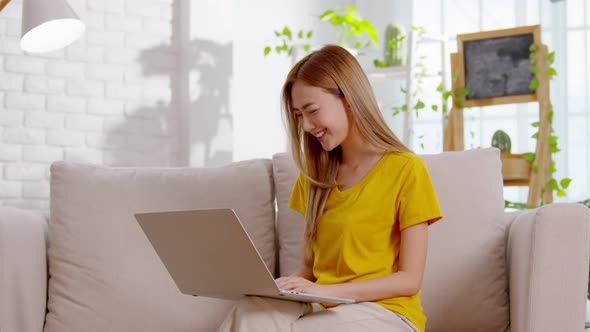 Asian girl is chatting and smiling with the laptop screen