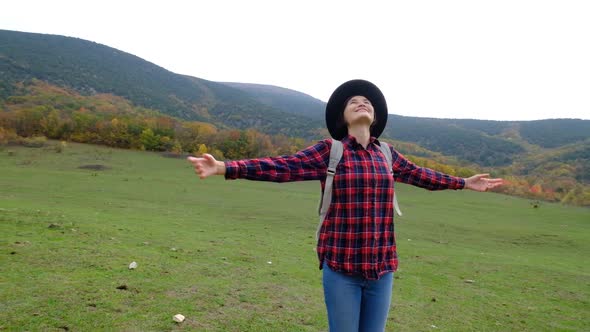 Beautiful Asian Woman in Plaid Shirt and Hat on the Background of Autumn Forest