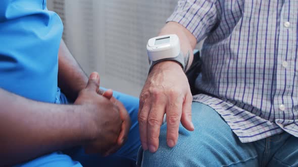 African-American caregiver and old disabled man in a wheelchair. Nurse and handicapped patient.