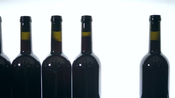 Sealed Bottles of Red Wine on White Background
