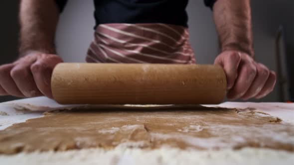 Baker Rolls Raw Brown Dough for Gingerbread with Rolling Pin