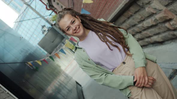 Rotating Portrait of Unique Girl with Dreadlocks Smiling Standing Outside in Modern City