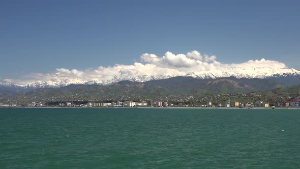 Seaside City Houses and Snowy Mountains in the Background