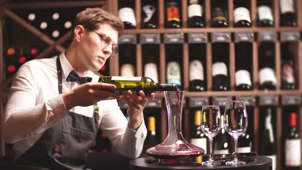 Skilled Sommelier Pouring Wine From Decanter Ino Wine Glass.