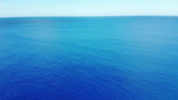 Camera flies over the blur ocean waves to  the clean horizon 