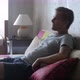 Handsome Young Man at Home Sitting on a Couch Watches TV Some Comedy - VideoHive Item for Sale