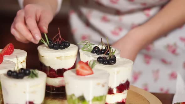 Cook Is Decorating Desserts in Glasses, By Strawberry, Whipped Cream, Chokeberry