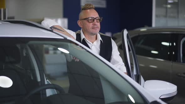 Elegant Adult Caucasian Man with Mohawk Haircut in Eyeglasses Posing at New Luxurious Expensive
