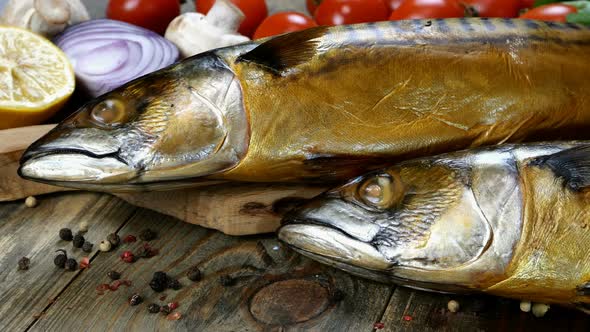 Delicious Smoked Fish Mackerel on a Wooden Table Next to the Cherry Tomatoes Onion