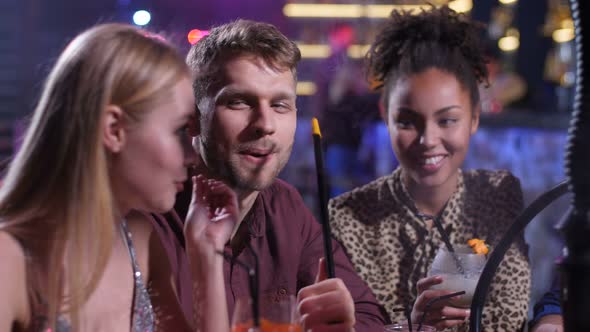 Joyful Friends Having Fun in Disco Bar with Hookah