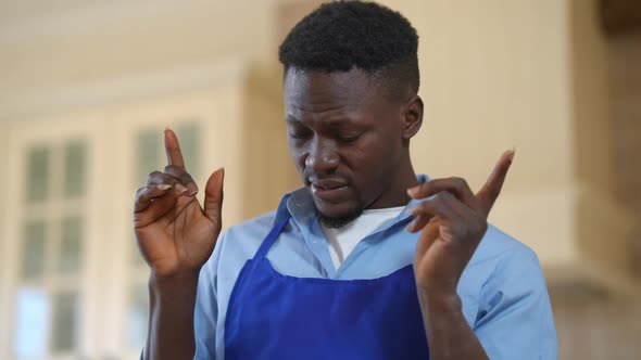 Overburdened African American Male Cook Rubbing Temples Having Headache Standing Indoors